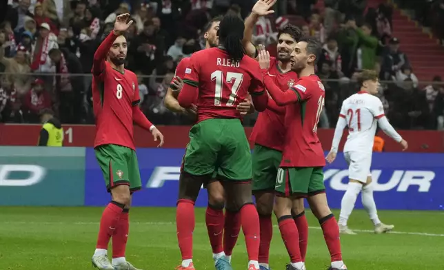 Portugal's Rafael Leao (17) is congratulated after assisting Cristiano Ronaldo for his side's second goal during the UEFA Nations League soccer match between Poland and Portugal at Narodowy stadium in Warsaw, Poland, Saturday, Oct. 12, 2024. (AP Photo/Czarek Sokolowski)