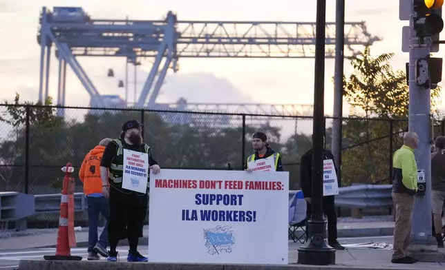 Dockworkers strike in front of an entrance to a container terminal near Boston Harbor, Tuesday, Oct. 1, 2024, in Boston. (AP Photo/Steven Senne)