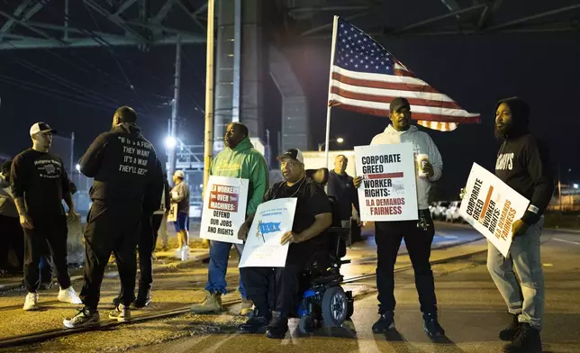 Boise Butler, president of Local 1291, with an American flag on his wheelchair, pickets with his fellow longshoremen outside the Packer Avenue Marine Terminal Port in Philadelphia, Tuesday, Oct. 1, 2024. (AP Photo/Ryan Collerd)