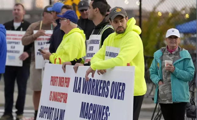 Dockworkers strike in front an entrance to a container terminal near Boston Harbor, Tuesday, Oct. 1, 2024, in Boston. (AP Photo/Steven Senne)