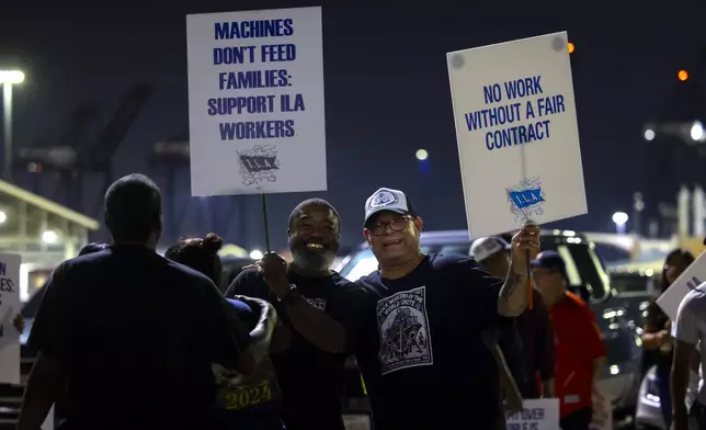 Longshoremen pose for a photo while picketing at Bayport Terminal on Tuesday, Oct. 1, 2024, in Houston. (AP Photo/Annie Mulligan)