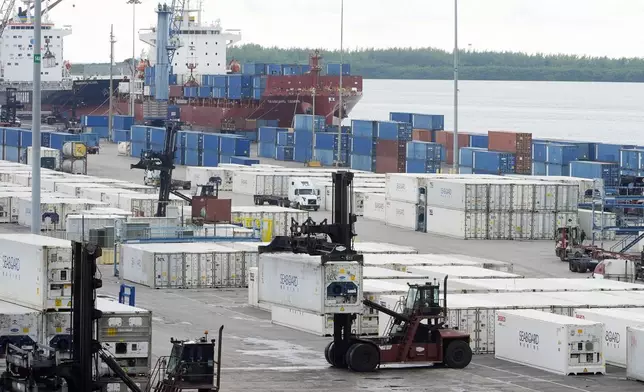 Dockworkers return to work at Port Miami, Friday, Oct. 4, 2024, in Miami, after the union representing 45,000 striking U.S. dockworkers at East and Gulf coast ports has reached a deal to suspend a three-day strike until Jan. 15 to provide time to negotiate a new contract. (AP Photo/Marta Lavandier)