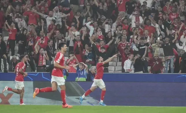 Benfica's Orkun Kokcu, right, celebrates after scoring his sides fourth goal during a Champions League opening phase soccer match between SL Benfica and Atletico Madrid in Lisbon, on Wednesday, Oct. 2, 2024.(AP Photo/Armando Franca)