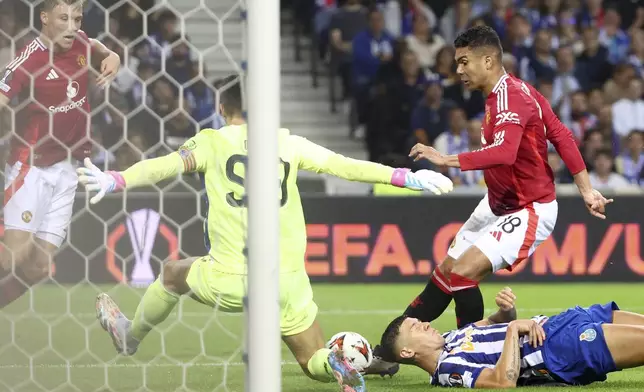 Manchester United's Casemiro, right, has a shot saved by Porto's goalkeeper Diogo Costa during a Europa League opening phase soccer match between FC Porto and Manchester United at the Dragao stadium in Porto, Portugal, Thursday, Oct. 3, 2024. (AP Photo/Luis Vieira)