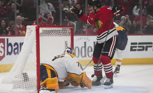 Chicago Blackhawks center Craig Smith, right, scores on Nashville Predators goaltender Juuse Saros during the first period of an NHL hockey game Friday, Oct. 25, 2024, in Chicago. (AP Photo/Erin Hooley)