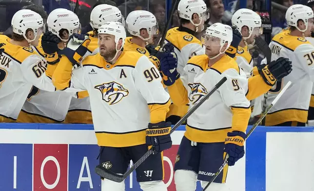 Nashville Predators center Ryan O'Reilly (90) and center Steven Stamkos (91) celebrate with the bench after O'Reilly's goal against the Tampa Bay Lightning during the second period of an NHL hockey game Monday, Oct. 28, 2024, in Tampa, Fla. (AP Photo/Chris O'Meara)