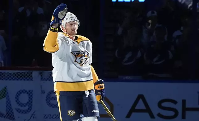 Nashville Predators center Steven Stamkos (91) waves to the crowd after a video tribute during the first period of an NHL hockey game against the Tampa Bay Lightning Monday, Oct. 28, 2024, in Tampa, Fla. Stamkos played for the Lightning for 16-seasons. (AP Photo/Chris O'Meara)