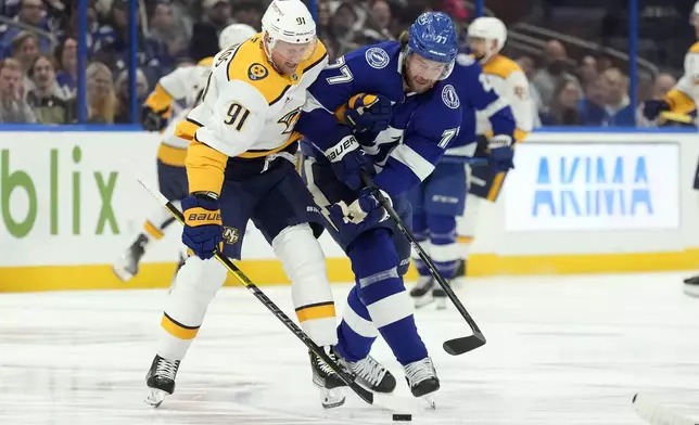 Nashville Predators center Steven Stamkos (91) and Tampa Bay Lightning defenseman Victor Hedman (77) battle for a loose puck during the first period of an NHL hockey game Monday, Oct. 28, 2024, in Tampa, Fla. (AP Photo/Chris O'Meara)