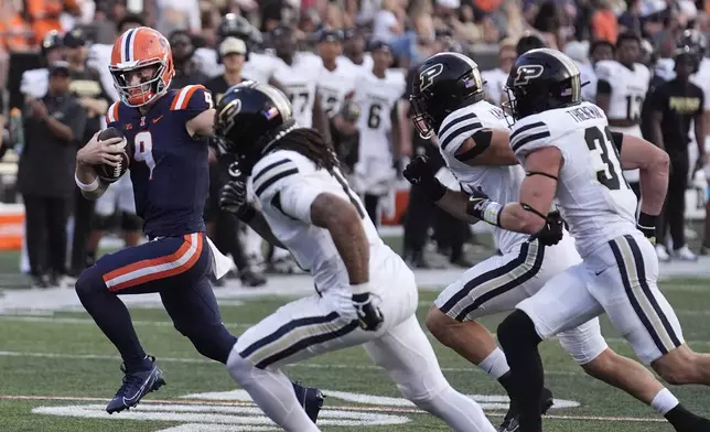 Illinois quarterback Luke Altmyer heads to the end zone for a touchdown past Purdue defenders during the second half of an NCAA college football game Saturday, Oct. 12, 2024, in Champaign, Ill. (AP Photo/Charles Rex Arbogast)