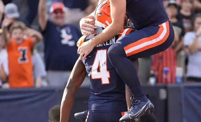 Illinois quarterback Luke Altmyer (9) touchdown pass to wide receiver Zakhari Franklin during the first half of an NCAA college football game against Purdue on Saturday, Oct. 12, 2024, in Champaign, Ill. (AP Photo/Charles Rex Arbogast)