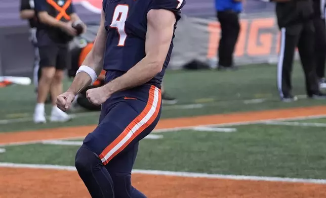 Illinois quarterback Luke Altmyer celebrates his touchdown during the second half of an NCAA college football game against Purdue on Saturday, Oct. 12, 2024, in Champaign, Ill. (AP Photo/Charles Rex Arbogast)