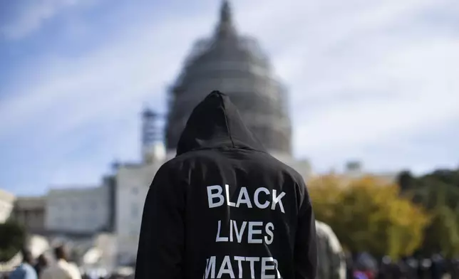 FILE - Neal Blair, of Augusta, Ga., wears a hoodie reading "Black Lives Matter" as he stands on the lawn of the Capitol building during a rally to mark the 20th anniversary of the Million Man March, on Capitol Hill, on Oct. 10, 2015, in Washington. (AP Photo/Evan Vucci, File)