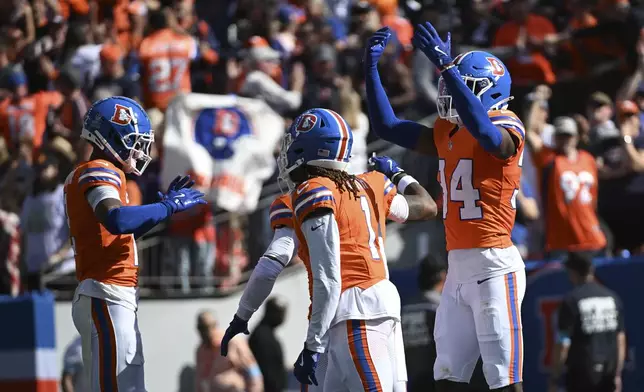 Denver Broncos cornerback Pat Surtain II, left, celebrates his 100-yard interception for a touchdown during the first half of an NFL football game against the Las Vegas Raiders, Sunday, Oct. 6, 2024, in Denver. (AP Photo/Geneva Heffernan)