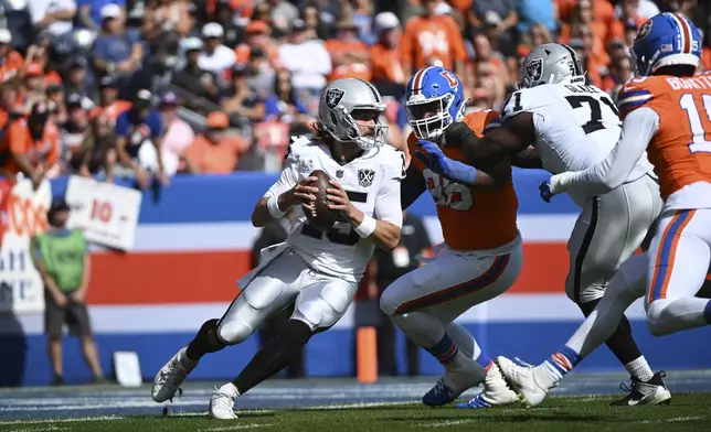 Las Vegas Raiders quarterback Gardner Minshew (15) scramble during the first half of an NFL football game against the Denver Broncos, Sunday, Oct. 6, 2024, in Denver. (AP Photo/Geneva Heffernan)