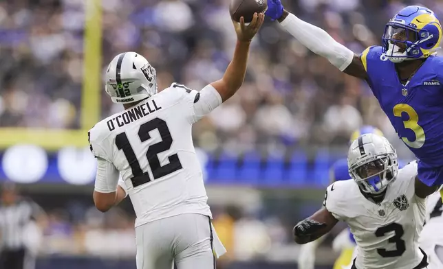 Las Vegas Raiders quarterback Aidan O'Connell (12) attempts to throw a pass as Los Angeles Rams safety Kamren Curl (3) jumps to defend during the first half of an NFL football game Sunday, Oct. 20, 2024, in Inglewood, Calif. (AP Photo/Ryan Sun)