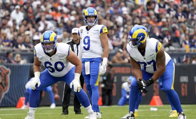 Los Angeles Rams quarterback Matthew Stafford looks over the Chicago Bears defense with guard Logan Bruss (60) snd offensive tackle Alaric Jackson during the first half of an NFL football game against the Chicago Bears on Sunday, Sept. 29, 2024, in Chicago. (AP Photo/Nam Y. Huh)