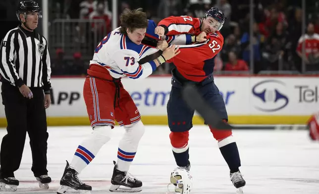 New York Rangers center Matt Rempe (73) and Washington Capitals defenseman Dylan McIlrath (52) fight during the first period of an NHL hockey game, Tuesday, Oct. 29, 2024, in Washington. (AP Photo/Nick Wass)