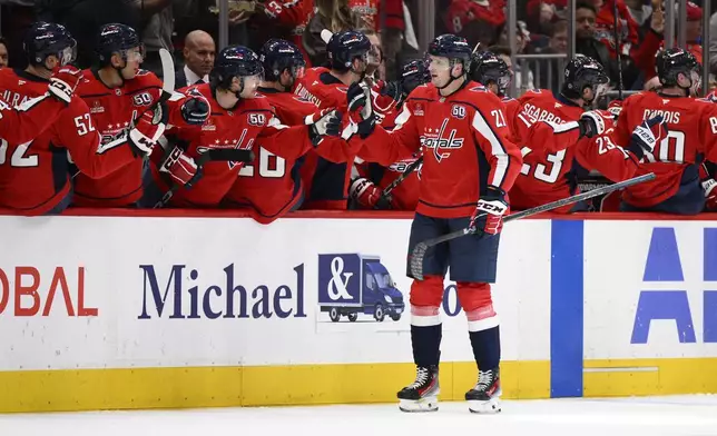 Washington Capitals center Aliaksei Protas (21) celebrates his goal at the bench during the second period of an NHL hockey game against the New York Rangers, Tuesday, Oct. 29, 2024, in Washington. (AP Photo/Nick Wass)