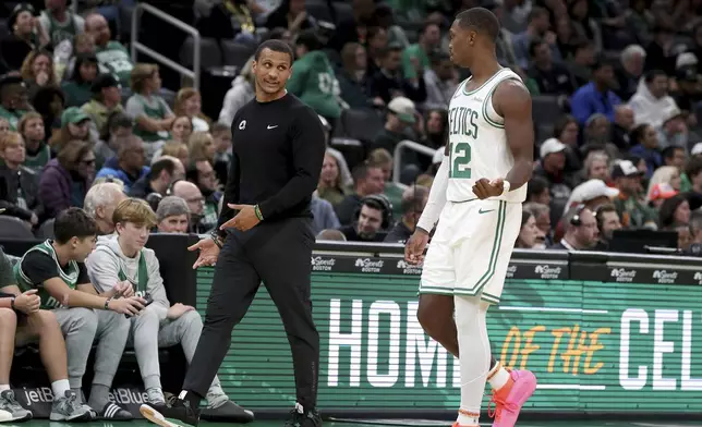 Boston Celtics head coach Joe Mazzulla, front left, speaks with Boston Celtics guard Lonnie Walker IV (12) who walks to the team bench during the second half of a preseason NBA basketball game against the Toronto Raptors, Sunday, Oct. 13, 2024, in Boston. (AP Photo/Mark Stockwell)