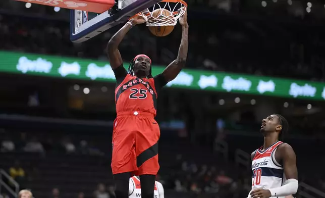 Toronto Raptors forward Chris Boucher (25) dunks past Washington Wizards forward Alex Sarr (20) during the first half of an NBA preseason basketball game, Friday, Oct. 11, 2024, in Washington. (AP Photo/Nick Wass)