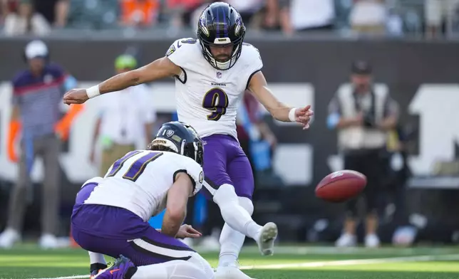 Baltimore Ravens kicker Justin Tucker (9), with Jordan Stout holding, boots the game winning field goal in overtime of an NFL football game, Sunday, Oct. 6, 2024, in Cincinnati. The Ravens won 41-38 in overtime. (AP Photo/Carolyn Kaster)