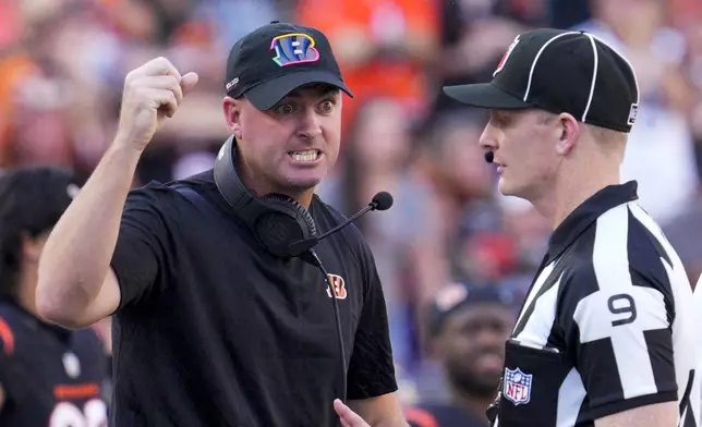 Cincinnati Bengals head coach Zac Taylor, center, reacts while talking to official Mark Perlman (9) during the second half of an NFL football game against the Baltimore Ravens, Sunday, Oct. 6, 2024, in Cincinnati. (AP Photo/Jeff Dean)