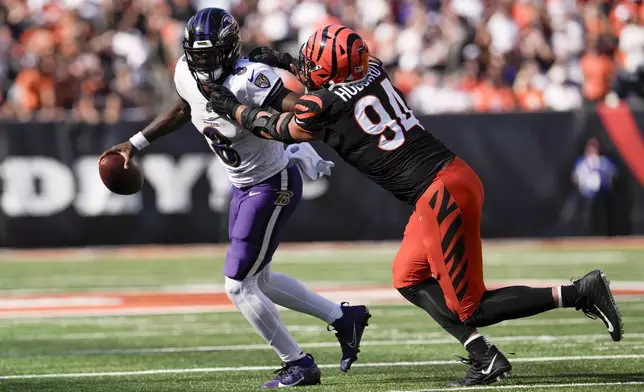 Baltimore Ravens quarterback Lamar Jackson (8) scrambles as Cincinnati Bengals defensive end Sam Hubbard (94) applies pressure during the second half of an NFL football game, Sunday, Oct. 6, 2024, in Cincinnati. (AP Photo/Jeff Dean)