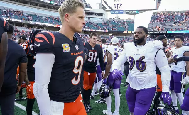 Cincinnati Bengals quarterback Joe Burrow, left, walks near Baltimore Ravens defensive tackle Broderick Washington following an NFL football game, Sunday, Oct. 6, 2024, in Cincinnati. The Ravens won 41-38 in overtime. (AP Photo/Jeff Dean)