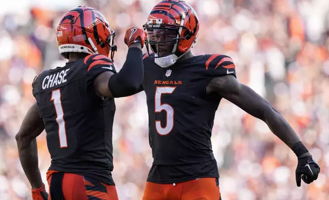 Cincinnati Bengals wide receiver Ja'Marr Chase (1) celebrates his long touchdown reception with wide receiver Tee Higgins (5) during the second half of an NFL football game against the Baltimore Ravens, Sunday, Oct. 6, 2024, in Cincinnati. (AP Photo/Jeff Dean)