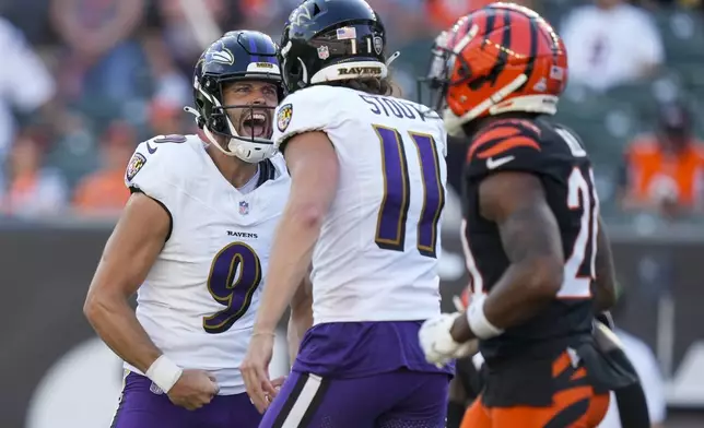 Baltimore Ravens kicker Justin Tucker, left, reacts with holder Jordan Stout after booting the game-winning field goal in overtime of an NFL football game, Sunday, Oct. 6, 2024, in Cincinnati. The Ravens won 41-38 in overtime. (AP Photo/Carolyn Kaster)