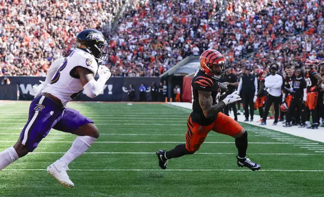 Cincinnati Bengals running back Chase Brown, right, runs in a touchdown after making a catch in front of Baltimore Ravens linebacker Trenton Simpson during the second half of an NFL football game, Sunday, Oct. 6, 2024, in Cincinnati. (AP Photo/Jeff Dean)