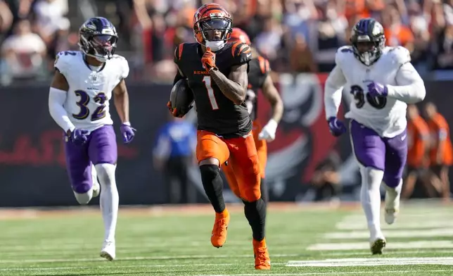 Cincinnati Bengals wide receiver Ja'Marr Chase (1) runs in front of Baltimore Ravens safety Marcus Williams (32) and running back Owen Wright (36) for a long touchdown after making a catch during the second half of an NFL football game, Sunday, Oct. 6, 2024, in Cincinnati. (AP Photo/Carolyn Kaster)