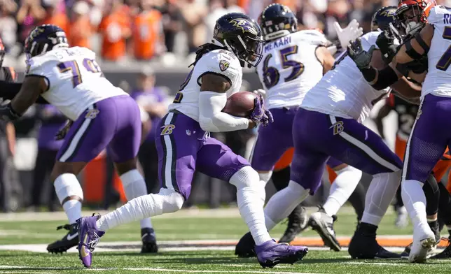 Baltimore Ravens running back Derrick Henry runs with the ball against the Cincinnati Bengals during the first half of an NFL football game, Sunday, Oct. 6, 2024, in Cincinnati. (AP Photo/Jeff Dean)