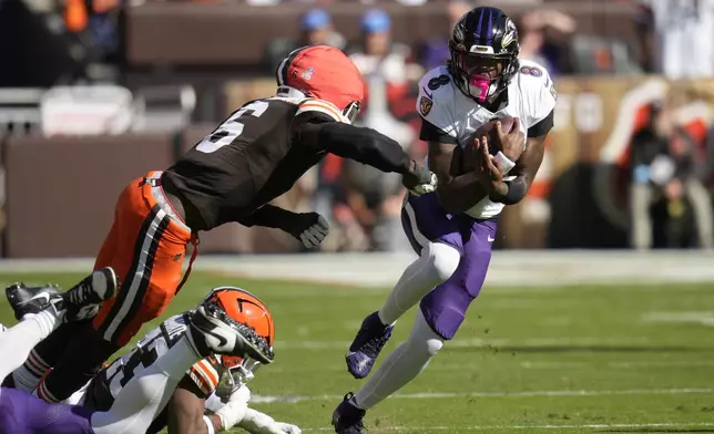 Baltimore Ravens quarterback Lamar Jackson (8) cuts past Cleveland Browns linebacker Jeremiah Owusu-Koramoah (6) during the first half of an NFL football game in Cleveland, Sunday, Oct. 27, 2024. (AP Photo/Sue Ogrocki)