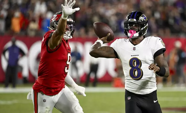 Baltimore Ravens quarterback Lamar Jackson (8) is pressured by Tampa Bay Buccaneers linebacker Joe Tryon-Shoyinka (9) during the first half of an NFL football game, Monday, Oct. 21, 2024, in Tampa, Fla. (AP Photo/Jason Behnken)