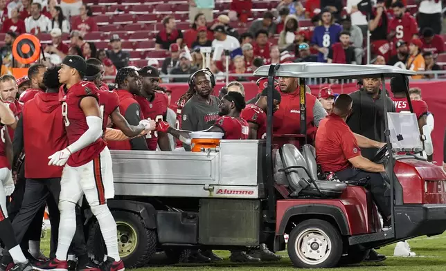 Tampa Bay Buccaneers wide receiver Chris Godwin (14) interacts with his teammates while being carted off of the field after an injury during the second half of an NFL football game against the Baltimore Ravens, Monday, Oct. 21, 2024, in Tampa, Fla. (AP Photo/Chris O'Meara)