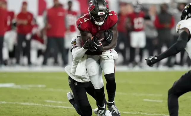 Tampa Bay Buccaneers wide receiver Chris Godwin (14) is stopped by Tampa Bay Buccaneers running back Sean Tucker, rear, after a reception during the first half of an NFL football game, Monday, Oct. 21, 2024, in Tampa, Fla. (AP Photo/Chris O'Meara)