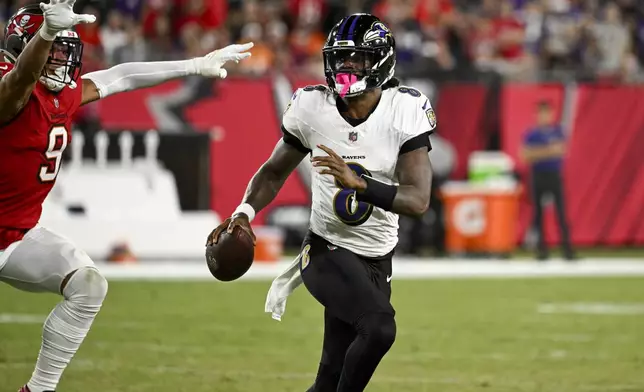 Baltimore Ravens quarterback Lamar Jackson is pressured by Tampa Bay Buccaneers linebacker Joe Tryon-Shoyinka (9) during the first half of an NFL football game, Monday, Oct. 21, 2024, in Tampa, Fla. (AP Photo/Jason Behnken)