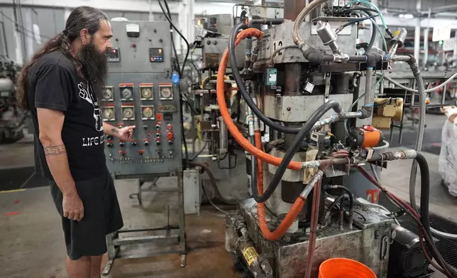 Chuck Springer operates a record pressing machine at the United Record Pressing plant July 11, 2024, in Nashville, Tenn. (AP Photo/George Walker IV)