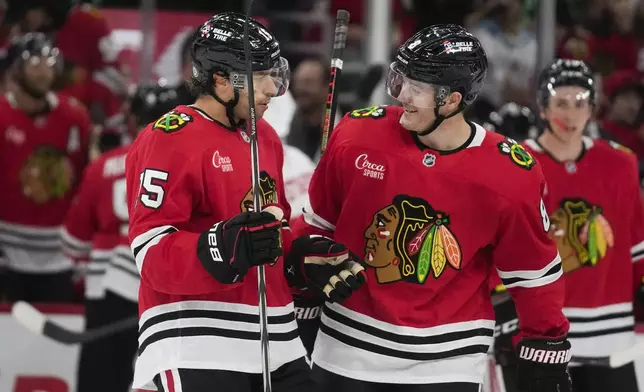 Chicago Blackhawks center Craig Smith (15), left, and center Ryan Donato (8) celebrate Smiths' goal on the Detroit Red Wings during the second period of an NHL hockey game, Wednesday, Sept. 25, 2024, in Chicago. (AP Photo/Erin Hooley)