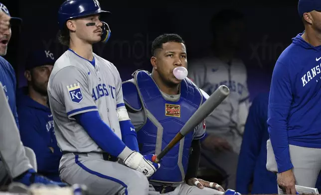 Kansas City Royals' Bobby Witt Jr., left, and catcher Salvador Perez, right, look on from the dugout during the fourth inning of a baseball game against the Washington Nationals, Wednesday, Sept. 25, 2024, in Washington. (AP Photo/Nick Wass)