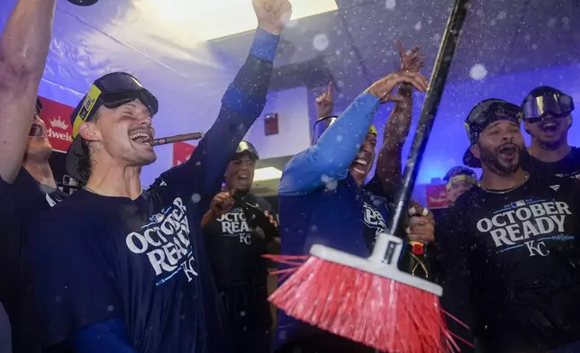 Kansas City Royals shortstop Bobby Witt Jr., left, catcher Salvador Perez, center, and outfielder Tommy Pham, right, celebrate with teammates after defeating the Baltimore Orioles 2-1 in Game 2 of an AL Wild Card Series baseball game, Wednesday, Oct. 2, 2024 in Baltimore. (AP Photo/Stephanie Scarbrough)