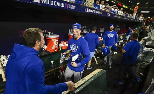 Kansas City Royals shortstop Bobby Witt Jr., center, reacts with a staff member after defeating the Baltimore Orioles 2-1 in Game 2 of an AL Wild Card Series baseball game, Wednesday, Oct. 2, 2024 in Baltimore. (AP Photo/Nick Wass)