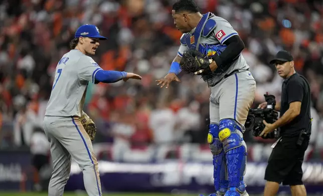 Kansas City Royals shortstop Bobby Witt Jr. (7) and catcher Salvador Perez celebrate their team's win over the Baltimore Orioles after Game 1 of an AL Wild Card Series baseball game, Tuesday, Oct. 1, 2024, in Baltimore. (AP Photo/Stephanie Scarbrough)