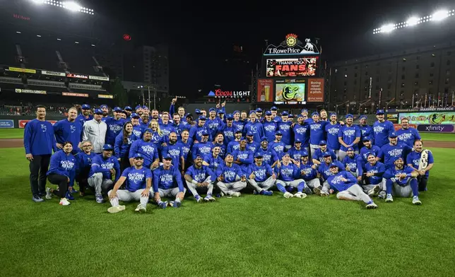 Kansas City Royals players and staff pose for photographers after defeating the Baltimore Orioles 2-1 in Game 2 of an AL Wild Card Series baseball game, Wednesday, Oct. 2, 2024 in Baltimore. (AP Photo/Nick Wass)