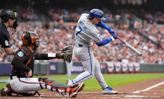 Kansas City Royals' Bobby Witt Jr. (7) hits a single as home plate umpire Ben May, left, and Baltimore Orioles catcher Adley Rutschman look on during the third inning in Game 2 of an AL Wild Card Series baseball game, Wednesday, Oct. 2, 2024 in Baltimore. (AP Photo/Stephanie Scarbrough)