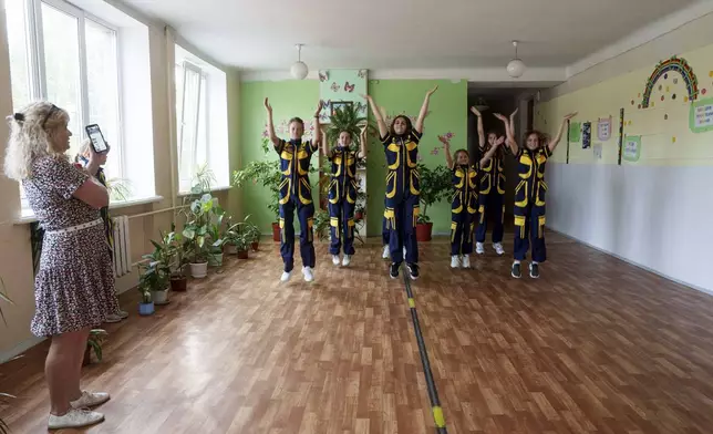 Children from School No. 88 rehearse a dance before the traditional back-to-school ceremony in Zaporizhzhia, Ukraine, Aug. 30, 2024. (AP Photo/Evgeniy Maloletka)