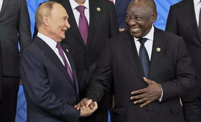 Russian President Vladimir Putin, left, and South African President Cyril Ramaphosa shake hands during a family photo ceremony prior to Outreach/BRICS Plus format session at BRICS Summit in Kazan, Russia, Thursday, Oct. 24, 2024. (Alexander Nemenov, Pool Photo via AP)