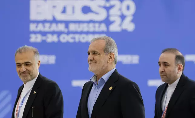 Iranian President Masoud Pezeshkian, center, accompanied by Iranian Ambassador to Russia Kazem Jalali, left, arrives at BRICS Summit in Kazan, Russia, Wednesday, Oct. 23, 2024. (Maxim Shemetov/Pool Photo via AP)