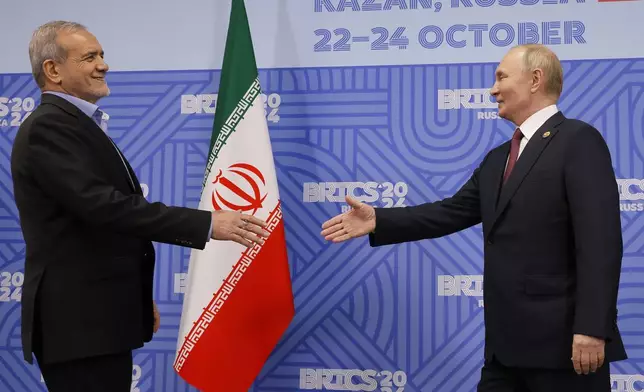 Russian President Vladimir Putin, right, and Iranian President Masoud Pezeshkian shake hands during their meeting on the sidelines of the BRICS summit in Kazan, Russia, Wednesday, Oct. 23, 2024. (Maxim Shemetov, Pool Photo via AP)